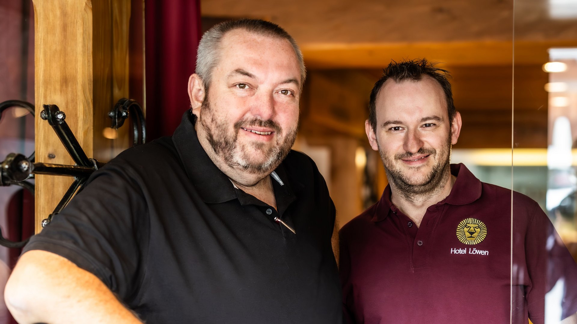 Ihre Gastgeber im Hotel Löwen Die zwei Chefs im Hotel Löwen stehen nebeneinander und lächeln in die Kamera